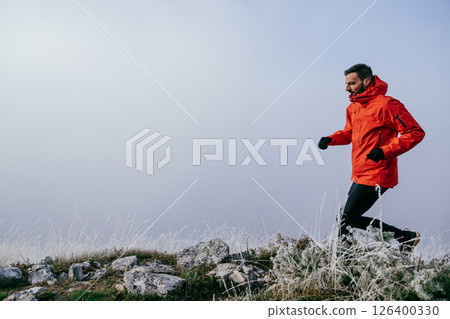 Man Climbing Rocky Hill in Fog 126400330