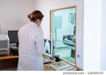 Radiologist Analyzing X-Ray Scans in a Medical Imaging Room. 126400335