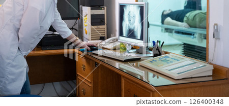 Radiologist Analyzing X-Ray Scans in a Medical Imaging Room. 126400348