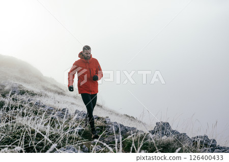Man Climbing Rocky Hill in Fog 126400433