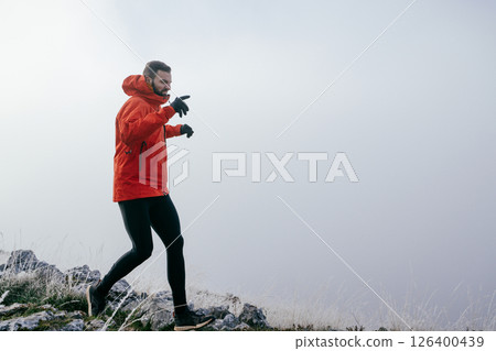 Man Climbing Rocky Hill in Fog Man Climbing Rocky Hill in Fog 126400439