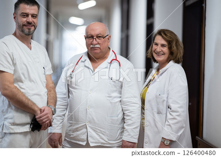 A team of experienced doctors standing in the hospital hallway, weary but dedicated after a long day of caring for patients. 126400480