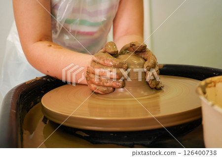 Hands, pottery wheel and girl with clay, artist and creativity in workshop, productivity and tools. Closeup, entrepreneur and person with equipment, designer and hobby with small business or talent Hands, pottery wheel and girl with clay, artist and creativity in workshop, productivity and tools. Closeup, entrepreneur and person with equipment, designer and hobby with small business or talent 126400738