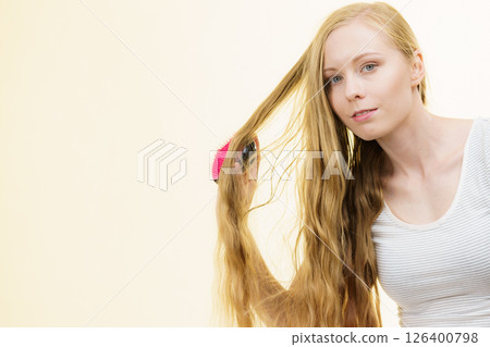 Blonde girl brushing her long hair 126400798