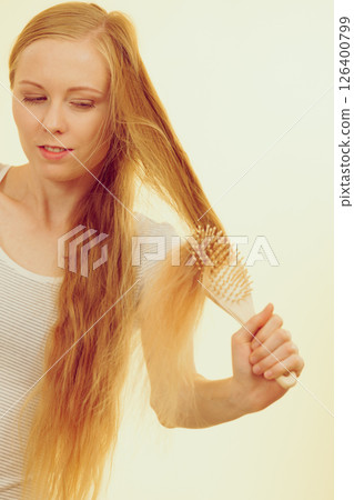 Blonde girl brushing her long hair 126400799