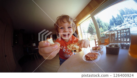 Happy child enjoying a delicious snack in natural daylight, captured with a fish eye lens. Generated image 126400924