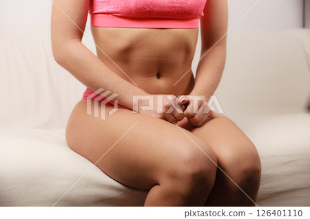 woman fit slim tanned body sitting on couch woman fit slim tanned body sitting on couch 126401110