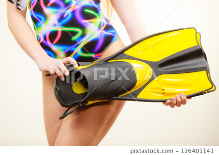 Woman in swimsuit holds flippers Woman in swimsuit holds flippers 126401141