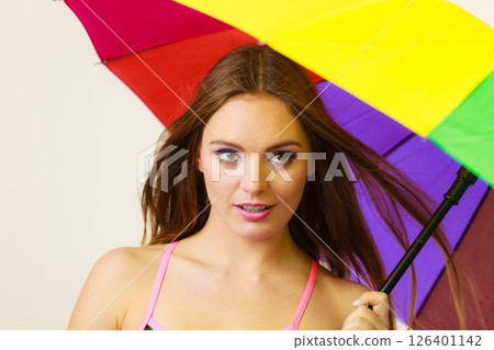 Woman standing under colorful rainbow umbrella Woman standing under colorful rainbow umbrella 126401142