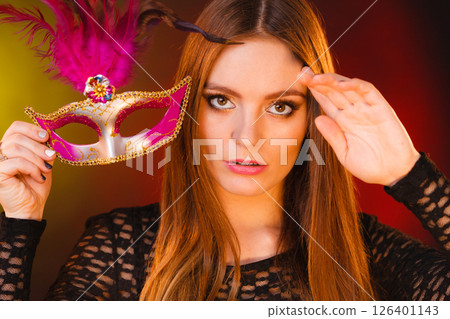 Woman holds carnival mask closeup 126401143