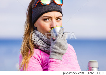 Fit woman in cold day warming up drink tea 126401410