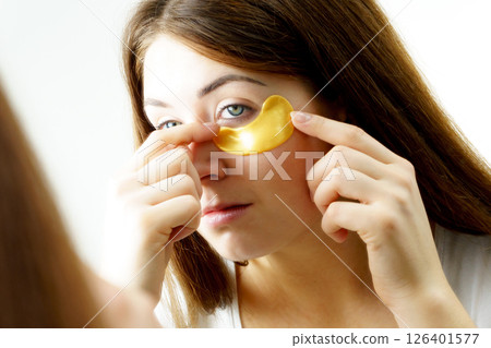Woman with gold patches under eyes 126401577