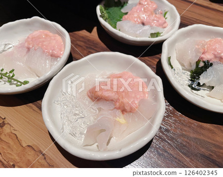 Filefish liver salad: A refined white fish sashimi dish with rich liver sauce. Filefish liver salad: A refined white fish sashimi dish with rich liver sauce. 126402345