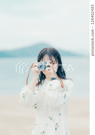 Profile portrait of a natural woman holding a film camera 126402483