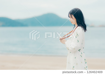 Profile portrait of a natural woman holding a film camera Profile portrait of a natural woman holding a film camera 126402489