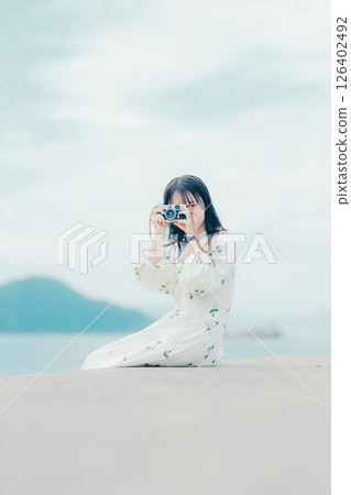 手持底片相機的自然女性側面肖像 手持底片相機的自然女性側面肖像 126402492
