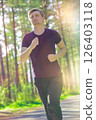 Man jogging in city partk at beautiful summer day. Sport fitness model caucasian ethnicity training outdoor. 126403118