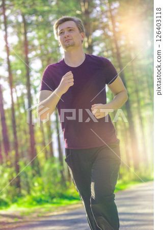 Man jogging in city partk at beautiful summer day. Sport fitness model caucasian ethnicity training outdoor. 126403118