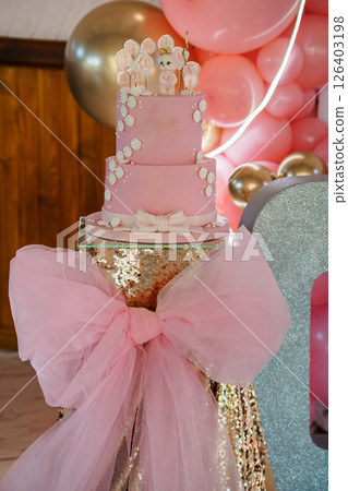 A Stunning Three-Tiered Pink Baby Girl Cake with Teddy Bear Topper, Balloons, and Rose Gold Accents for a Celebration A Stunning Three-Tiered Pink Baby Girl Cake with Teddy Bear Topper, Balloons, and Rose Gold Accents for a Celebration 126403198