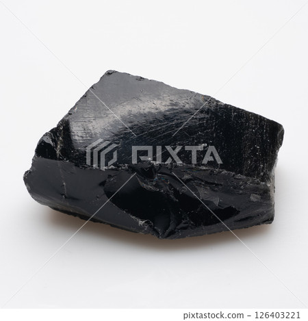 A raw, dark, glossy obsidian specimen featuring a rough, fractured surface with fine striations, exhibiting a reflective sheen and a black color, on a plain background 126403221
