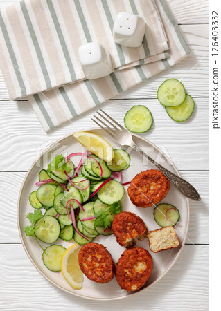 dutch fish cakes with cucumber salad on a plate 126403332
