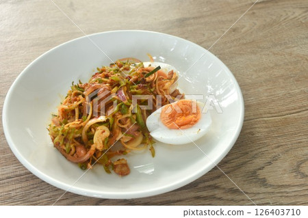 spicy and sour slice wing bean and banana blossom with chop pork sauce topping boiled egg Thai salad on plate 126403710