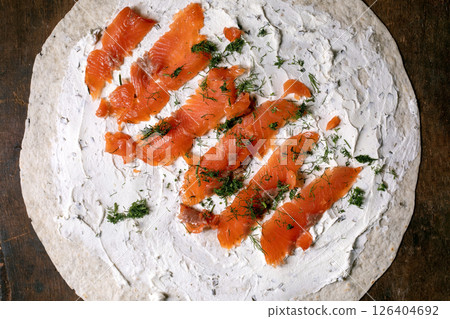 Homemade flatbread topped with cream cheese smoked salmon slices fresh dill on wooden table. Perfect appetizer or breakfast dish. Homemade flatbread topped with cream cheese smoked salmon slices fresh dill on wooden table. Perfect appetizer or breakfast dish. 126404692