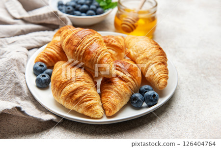 Freshly baked croissants with blueberries and honey for breakfast Freshly baked croissants with blueberries and honey for breakfast 126404764