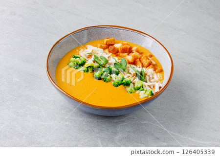 Creamy Pumpkin Soup with Broccoli Chicken Croutons and Parmesan in Ceramic Bowl Creamy Pumpkin Soup with Broccoli Chicken Croutons and Parmesan in Ceramic Bowl 126405339