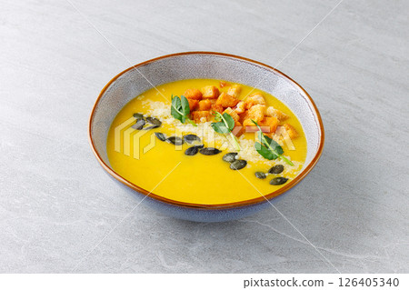 Pumpkin Soup with Croutons Parmesan Seeds and Microgreens in Ceramic Bowl Pumpkin Soup with Croutons Parmesan Seeds and Microgreens in Ceramic Bowl 126405340