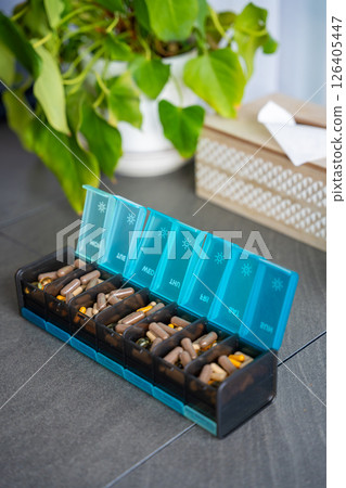 Weekly pill organizer with labeled compartments for daily medication doses. Concept of health management and medication planning 126405447