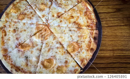 Delicious Thin Crust Cheese Pizza Cut Into Eight Slices on a Wooden Table Delicious Thin Crust Cheese Pizza Cut Into Eight Slices on a Wooden Table 126405891