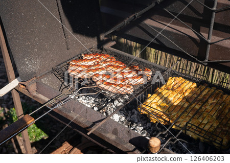 Grilled sausages and chicken on barbecue grill outdoors on a sunny day 126406203