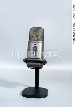 Modern gray microphone on stand against light background 126406205