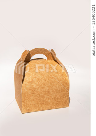 Eco-friendly brown kraft paper box with handle on light background 126406221