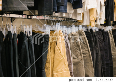 Assorted casual pants hanging in retail store display Assorted casual pants hanging in retail store display 126406232