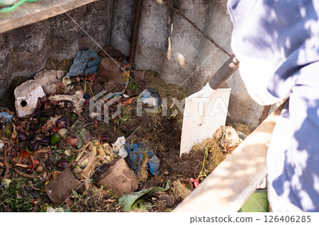 Composting process in a wooden bin with organic waste and shovel. Learn About Composting Day Composting process in a wooden bin with organic waste and shovel. Learn About Composting Day 126406285