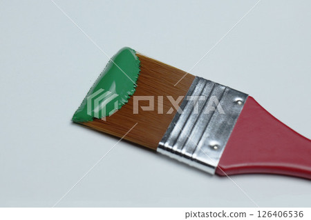 Painting with a green brush on a canvas in a bright studio. High quality photo Painting with a green brush on a canvas in a bright studio. High quality photo 126406536