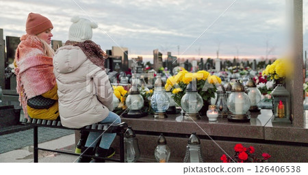 A group of children thoughtfully reflecting in a serene cemetery during the autumn season 126406538