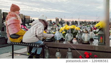 A group of children thoughtfully reflecting in a serene cemetery during the autumn season A group of children thoughtfully reflecting in a serene cemetery during the autumn season 126406561