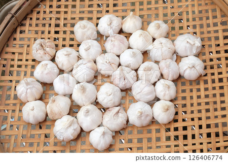 Fresh Garlic on a woven bamboo tray ,Drying on the sun. 126406774