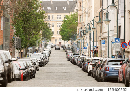 Scenic view Magdeburg Altstadt Leibniz street modern cars covered parked row roadside sunny summer day. Sidewalk parallel side parking full of vehicles traffic jam in downtown 126406862
