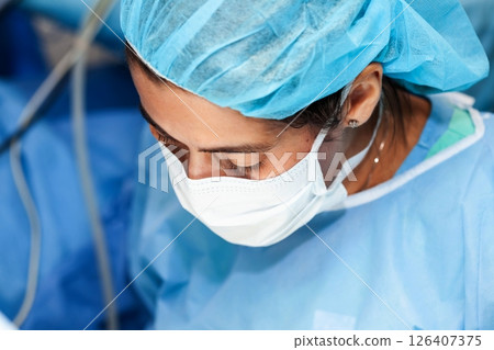 Female doctor performing a surgery. Surgery and insurance concept. 126407375