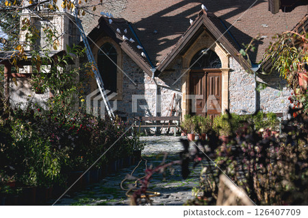 Doves resting on the tiled roof of a traditional stone church in Platanistasa, a picturesque village nestled in the Troodos 126407709