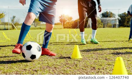 Sports field, legs and children with ball, kick and athlete with coach for practice in morning or cardio. Playing, football and kids with sportswear for game, growth and development with fitness 126407740