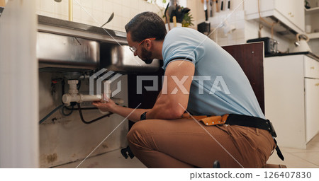 Man, plumber and inspection in kitchen, pipe and sink with search for leak, problem solving and repair in home. Person, handyman and check for water, drain and solution for maintenance at apartment Man, plumber and inspection in kitchen, pipe and sink with search for leak, problem solving and repair in home. Person, handyman and check for water, drain and solution for maintenance at apartment 126407830