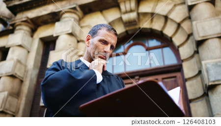 Thinking, reading and judge and mature man in city for trial report, policy legislation and legal documents. Lawyer idea, attorney paperwork and vision with person at courtroom outdoor in low angle 126408103