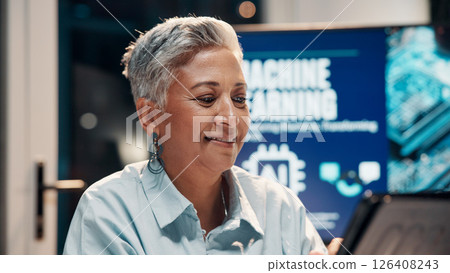 Business, smile and tablet with woman in office at night for ai development or machine learning. App, planning and research with mature employee at work for information review in late evening 126408243