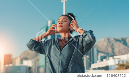City, fitness and music with woman outdoor for break from cardio or running routine. Exercise, headphones and streaming with athlete or runner in urban town for marathon, sports or workout challenge 126408312