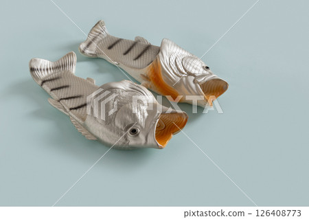 Rubber slippers shaped of fish. Fishermen slippers for beach on blue background. Summer vacation. Creative funny flip flops. Rubber slippers shaped of fish. Fishermen slippers for beach on blue background. Summer vacation. Creative funny flip flops. 126408773